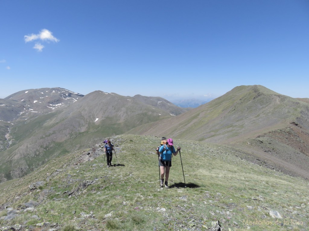 Txell y Olga dejando la cima del Pic de Finestrelles a la derecha, el Puigmal a la izquierda y en el centro-izquierda el Puigmal de Segre